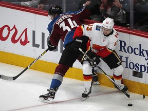 Calgary Flames left wing Johnny Gaudreau, right, looks to pass the puck as Colorado Avalanche center Carl Soderberg defends in the first period of Game 3 of a first-round NHL hockey playoff series Monday, April 15, 2019, in Denver. (AP Photo/David Zalubowski) ORG XMIT: CODZ105