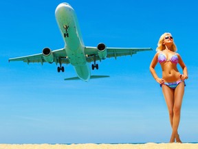 A bikini-clad woman poses as an airplane takes off at Thailand's Mai Khao beach. (Getty Images)