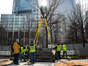 In this photo provided by the 9/11 Memorial & Museum, a crane finishes lowering one the granite monoliths to the ground for installation at the 9/11 Memorial, Saturday, April 6, 2019 in New York.
