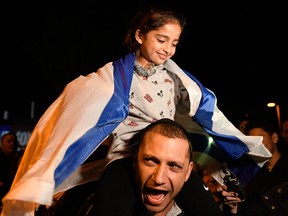 Noya Dahan, 8, rides on the shoulders of her father, Israel Dahan, at a candlelight vigil held for victims of the Chabad of Poway synagogue shooting, Sunday, April 28, 2019, in Poway, Calif.