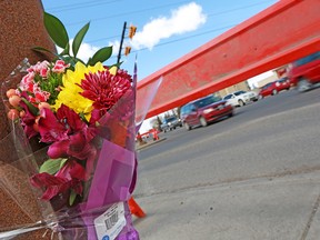 A bouquet of flowers is taped to a light post at 32nd Avenue and 26th Street N.E. where a pedestrian was killed on Monday, April 22, 2018.