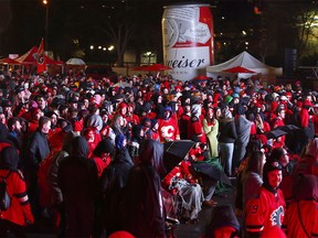 Flames fans react to the action on a giant outdoor TV as thousands join the C of Red to watch Game 5 at the "Red Lot" community viewing party outside the Dome. Friday, April 19, 2019.