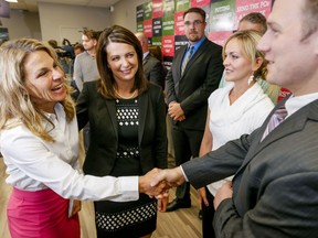 UCP MLAs Jeremy and Jason Nixon will be the first brothers elected to serve in the Alberta legislature simultaneously. A 2014 file photo shows Jeremy Nixon shake hands with Kathy MacDonald while both were candidates for the Wildrose Party. Then-Wildrose leader Danielle Smith and Jason Nixon (back) look on at the Edgemont Community Hall in Calgary.