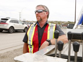 Neal Joad has been an operator with AMA for over 17 years. Joad is pictured working on a vehicle along Blackfoot Trail. Today is the first designated National Slow Down and Move Over Day that raises awareness operators and first responders who work along the side of the road. Tuesday, May 14, 2019. Brendan Miller/Postmedia