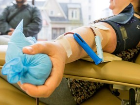 A blood donor gives blood at a Canadian Blood Services office in Calgary, May 16, 2015. (Lyle Aspinall/Calgary Sun/Postmedia Network)