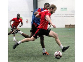 Cavalry FC Nico Pasquotti moves the ball upfield and is marked by Elijah Adekugbe during a training session at the Foothills Fieldhouse in Calgary, AB on Monday, March 25, 2019. Jim Wells/Postmedia