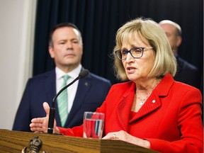 Alberta Premier Jason Kenney listens to Janice MacKinnon, a former Saskatchewan finance minister, and chair of a blue-ribbon panel announced to examine the Alberta government's financial situation.