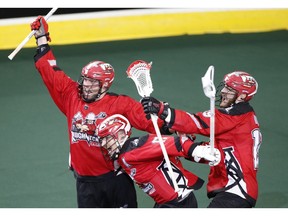 Calgary Roughnecks Rhys Duch, left, celebrates with Curtis Dickson, middle, and Jesse King, right, his overtime goal for a Champions Cup win over the Buffalo Bandits after NLL (National Lacrosse League) lacrosse playoff action in Calgary, Alta., on Sat., May 25, 2019.