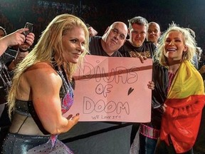 Beth Phoenix, left, and Nattie Neidhart, right, pose with a fan's sign during WWE's European tour.