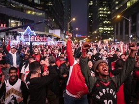 Toronto Raptors fans react as they watch game six of NBA Eastern Conference Final basketball action between the Toronto Raptors and Milwaukee Bucks on a screen outside the Scotiabank Arena, in Toronto on Saturday, May 25, 2019. (THE CANADIAN PRESS/Chris Young)