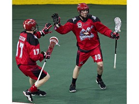 Calgary's Curtis Dickson, left, and Jon Harnett celebrate Harnett's goal during the second half of the Edmonton Rush's NLL lacrosse playoff game against the Calgary Roughnecks at Rexall Place in Edmonton, Alta., on Friday, May 16, 2014. Codie McLachlan/Edmonton Sun/QMI Agency