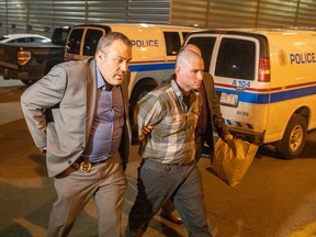 Robert Leeming is brought into arrest processing by Calgary Police Service detectives late Monday night.