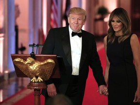 U.S. President Donald Trump with first lady Melania Trump smiles at the invited guests during a White House Historical Association Dinner in the East Room of the White House, Wednesday, May 15, 2019, in Washington.