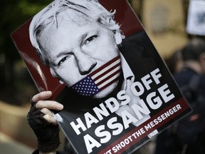 In this May 1, 2019, file photo, protesters demonstrate outside court where Julian Assange will appear in London. The Justice Department has charged Assange with receiving and publishing classified information. The charges are contained in a new, 18-count indictment announced May 23, 2019.