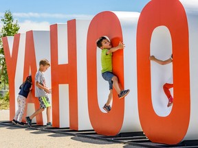 Kids play with a Yahoo sign on Riverwalk in East Village on Friday, June 28, 2019.