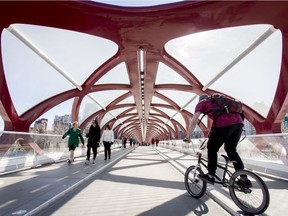 People walk and cycle across the Peace Bridge in downtown Calgary.