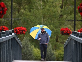 Kent Miller walks across leading from Prince's Island to Eau Claire in downwtown Calgary on Friday, June 21, 2019. He was on his way to the Great Trail Treasure Hunt on Prince's Island. Steady rain on Friday and the weekend could end upsetting the first official weekend of summer. Jim Wells/Postmedia