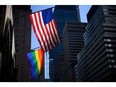 A rainbow flag and a US flag are seen in front of the St Bartholomew's Church on June 11, 2019 in New York City.