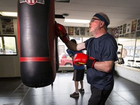 Darcy Henton works on the heavy bag during a boxing class for people with Parkinson's disease at Avenue Boxing Club in Edmonton.