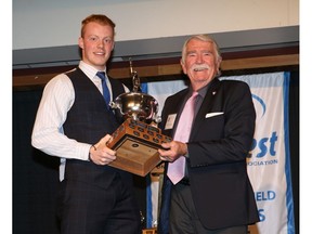 Calgary,Alberta; April. 7 2015 -- University of Calgary Andrew Buckley being awarded the Dr. Dennis Kadatz Trophy (by Dr. Kadatz himself) for Male Athlete of the Year Tuesday night at the Red & White Club   ({David Moll}/Calgary Herald) For {} story by {Rita Mingo}