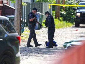 Calgary police investigate the scene where a woman was fatally shot by an officer in a southeast back lane on Wednesday, June 26, 2019.
