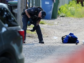 Calgary police investigate at the scene of an early morning officer involved shooting in alley in the 2000 block of 35th Street S.E. on Wednesday, June 26, 2019.