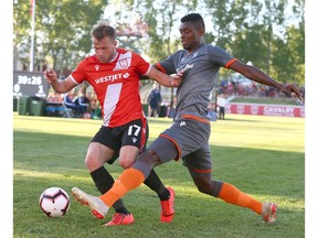 Cavalry FC Nico Pasquatti (L) is challenged by Forge FC Bertrand Owunid during CPL Action between the Hamilton Forge FC and Cavalry FC in Calgary at ATCO Field at Spruce Meadows onTuesday, June 11, 2019. Jim Wells/Postmedia