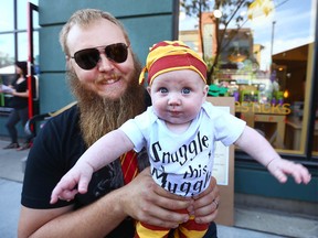 Nick Banack and daughter Brooke, 4 months old, from Edmonton, AB pose  on Sunday, July 30, 2017 as the northwest communities of Kensington and Sunnyside in Calgary are transformed into a magical wonderland for Harry Potter fans. Shops once again rolled out Potter-themed products and hold events for lovers of the popular book and movie franchise at the Spend a Day in Kensington's Diagon Alley event. Jim Wells/Postmedia