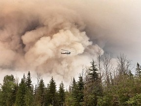 A helicopter battles the Chuckegg Creek fire near High Level, Alta.
