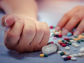 Overdose - close up of pills and addict lying on the floor