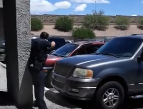 A police officer in Phoenix, Arizona points their gun at unarmed parents of a child that shoplifted. (Screenshot/Twitter)