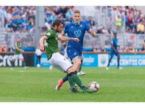 Canadian Premier League - HFX Wanderers FC vs Cavalry FC - Wanderers Grounds, Halifax, Nova Scotia - June 19, 2019.  Cavalry FC Defender Jonathan Wheeldon (14) kicks the ball down field past HFX Wanderers FC Attacker Tomasz Skublak (17).