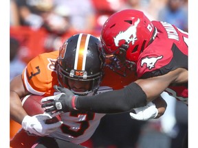 Lions John White (L) runs with the ball and is tackled by Stamps Wynton McManus during CFL action between the BC Lions and the Calgary Stampeders at McMahon Stadium in Calgary on Saturday, June 29, 2019. Jim Wells/Postmedia
