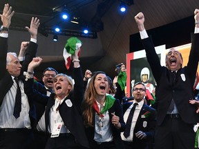 Members of the delegation of Milan/Cortina d'Ampezzo 2026 Winter Olympics candidate city react after the city was elected to host the 2026 Olympic Winter Games during the 134th session of the International Olympic Committee (IOC), in Lausanne on June 24, 2019.