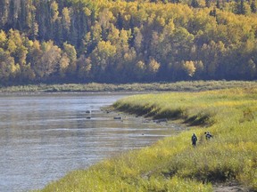 Two workers walk along the Athabasca River near the water treatment plant in Fort McMurray Alta. on Tuesday September 29, 2015. Garrett Barry/Fort McMurray Today/Postmedia Network