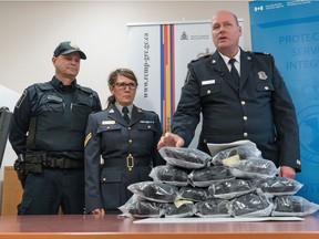 Border Services officer Cody Uytterhagen, left, RCMP Cpl. and Sharon Franks listen to CBSA Superintendent Darryl Anderson as he makes a statement regarding the seizure of 14.5kg of suspected methamphetamine in Southern, Alberta.   At the news conference in Raymond, Alberta, Friday, February 5, 2016, RCMP said they have charged Season, Truax, of Calgary with three counts under the Customs Act.