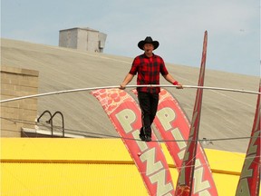 The King of the High Wire, Nik Wallenda, is seen on a high wire metres above the midway at the Stampede Grounds.