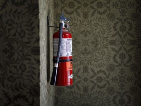 A fire extinguisher is seen against William Morris wallpaper in the Alumnae Theatre, a former firehall turned all female run theatre, Tuesday, July 16, 2019.  (Cole Burston/For National Post)