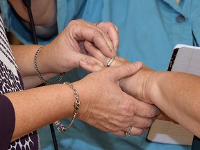 Two women place wedding bands on the finger of their partner as they renew their vows in a public ceremony on Oct. 24, 2015, in Morehead, Ky. (THE CANADIAN PRESS/AP, Timothy D. Easley)