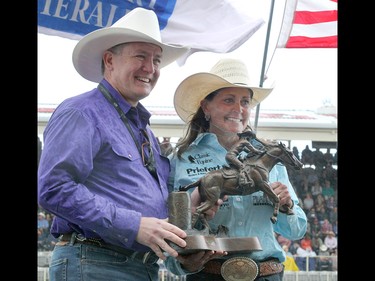 Calgary Herald Editor Lorne Motley presents Lisa Lockhart who won the Ladies Barrel Racing final in the Stampede Rodeo the bronze trophy at the Calgary Stampede in Calgary, Ab on Sunday, July 14, 2019. Brendan Miller/Postmedia