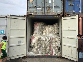 This handout photo taken on July 16, 2018 and released on July 17, 2019 by the Cambodian Ministry of Environment shows workers opening a container loaded with plastic waste after the shipment arrived at Sihanoukville port in Preah Sihanouk province.