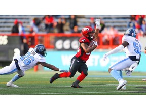 Calgary Stampeders Terry Williams takes off with the ball under pressure from Kevin Fogg of the Toronto Argonauts during CFL football in Calgary on Thursday, July 18, 2019. Al Charest/Postmedia