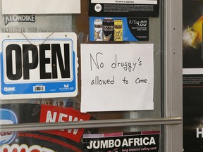 A sign hangs in the window of Happy Together Food Store in the Beltline near the Sheldon Chumir Health Centre.