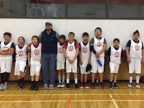 Basketball coach Truman Soop and members of the under 11 Kainai Basketball Association team pose in a handout photo. Players (from left) are Saxon Fox, Kashton Many Grey Horses, Logan Bruised Head, Aiden Across The Mountain, Payton Provost, Jyson Eagle Plume, Lance Wolf Child, Zennan Many Grey Horses and Kaydence Many Grey Horses. Young basketball players from a southern Alberta First Nation will be able to play in a tournament this week after a dispute with a Calgary referee group.