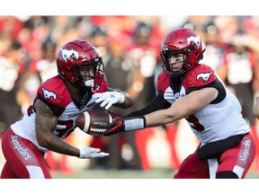 CP-Web.  Calgary Stampeders quarterback Nick Arbuckle passes off the ball to running back Terry Williams while taking on the Ottawa Redblacks during CFL action in Ottawa on Thursday, July 25, 2019.