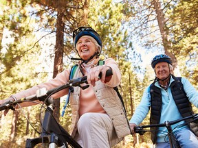 Senior couple mountain biking on a forest trail