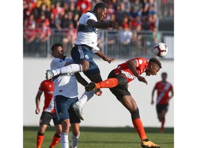 Cavalry FC Dominique Malonga (right) competes for the ball in front of Whitecaps FC defenders during first half CPL soccer Canadian Championship action between the Vancouver Whitecaps and Cavalry FC at ATCO Field at Spruce Meadows in Calgary on Wednesday, July 10. Jim Wells/Postmedia