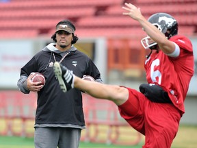 Stampeders special teams coordinator Mark Kilam works with punter Rob Maver during practice.