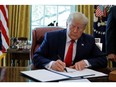 U.S. President Donald Trump signs an executive order imposing fresh sanctions in the Oval Office of the White House in Washington, U.S., June 24, 2019.