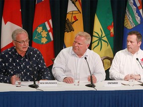 New Brunswick Premier Blaine Higgs speaks to media as Ontario Premier Doug Ford and Alberta Premier Jason Kenney look on. The Premier's were in Calgary to attend the Premier’s Stampede pancake breakfast at McDougall Centre in Calgary  Monday, July 8, 2019. Dean Pilling/Postmedia